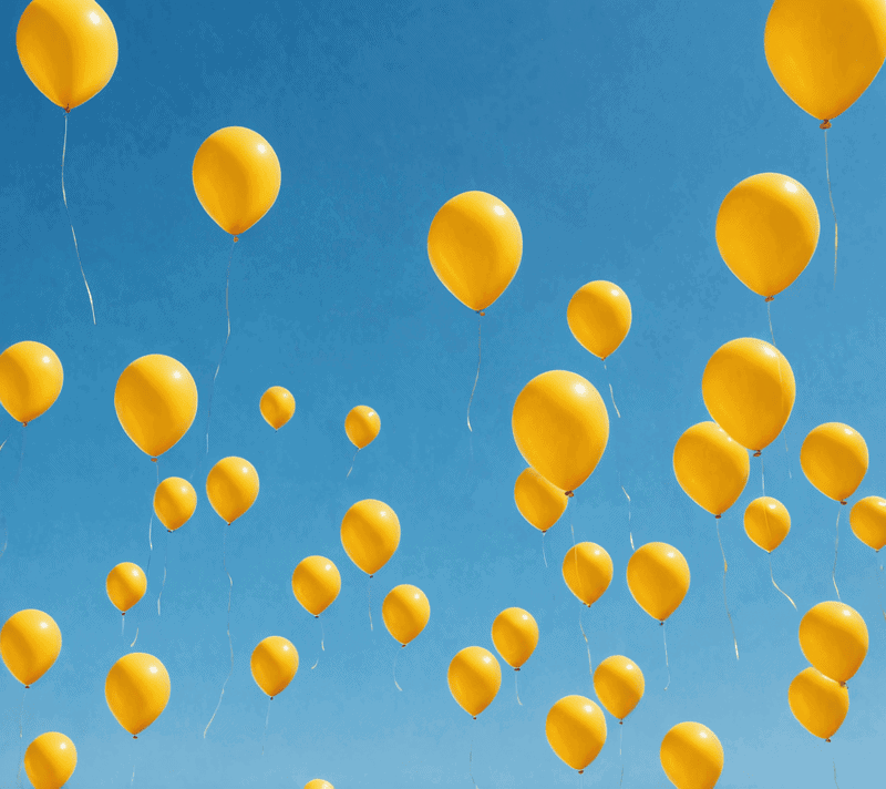 Bright yellow balloons against a clear blue sky