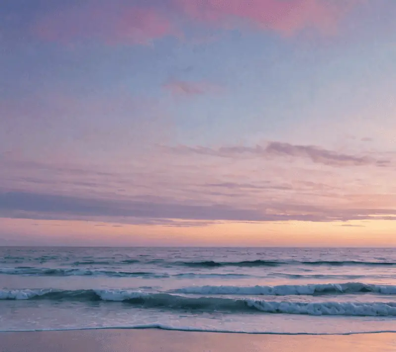 Soft sunrise over calm ocean waters, depicting new beginnings.