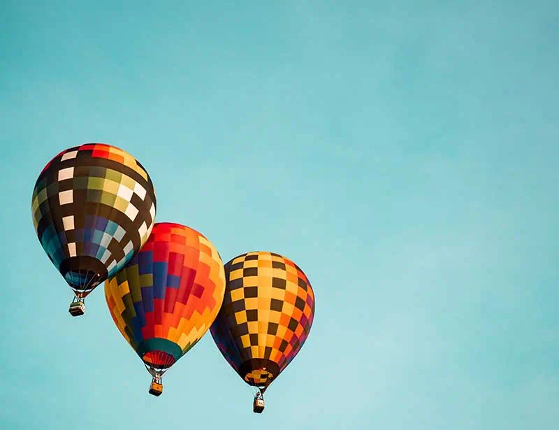 Three hot air balloons soared across the sky. 