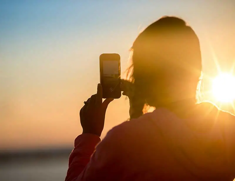 Person with a camera photographing the warm morning glow.