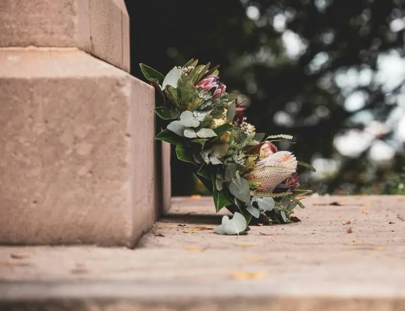 side view of memorial flower leaning on concrete 