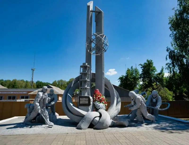 the monument of those who saved the world with red and white flowers in the middle located in Chernobyl