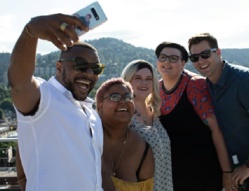 group of five friends using phone camera