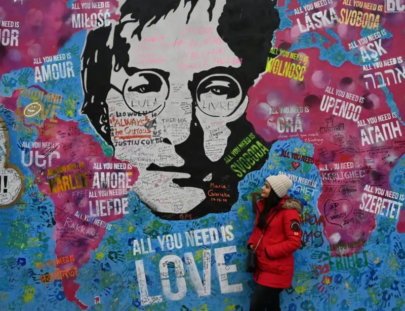 john lennon wall showing all you need is love with woman wearing red jacket