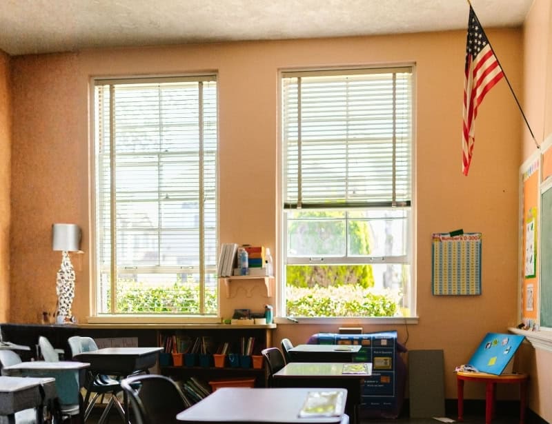 empty elementary classroom with hanging american flag