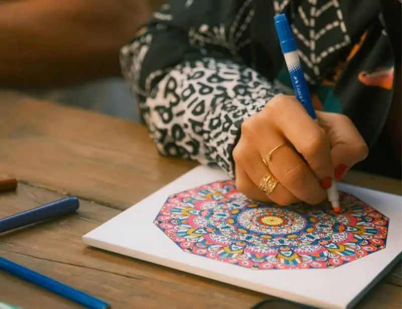 adult person coloring mandala on paper