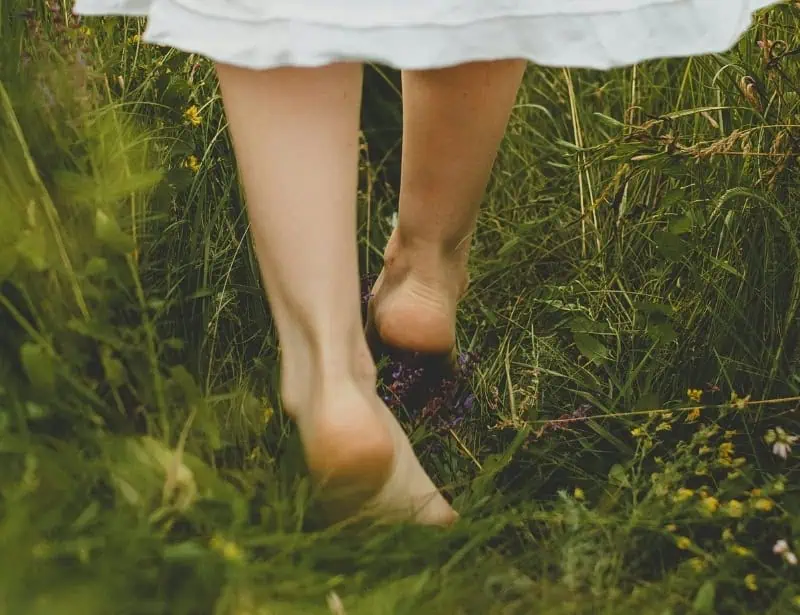 closeup of barefoot walking on green grass