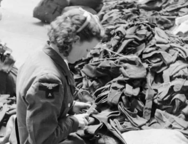 A female worker strips buttons from old garments at this salvage depot somewhere in Britain. Most of the salvaged material comes from woollen clothing. 