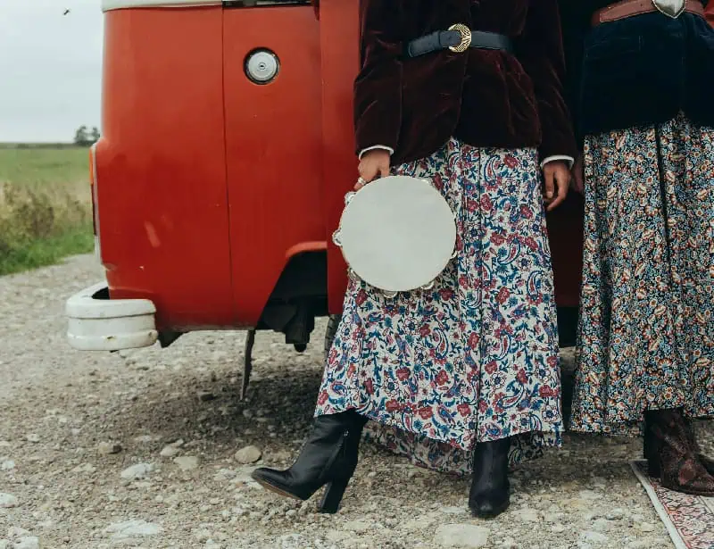 women with 70s floral skirt and tambourine