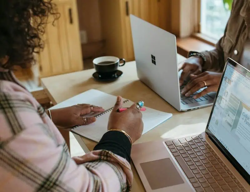 two person studying with laptops and notebooks