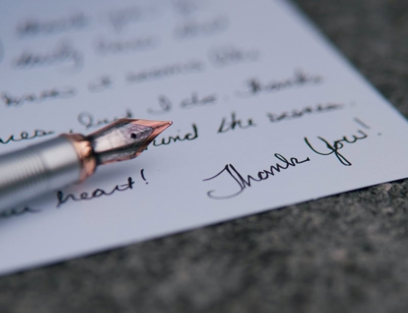 closeup of fountain pain and written letter with focus on thank you
