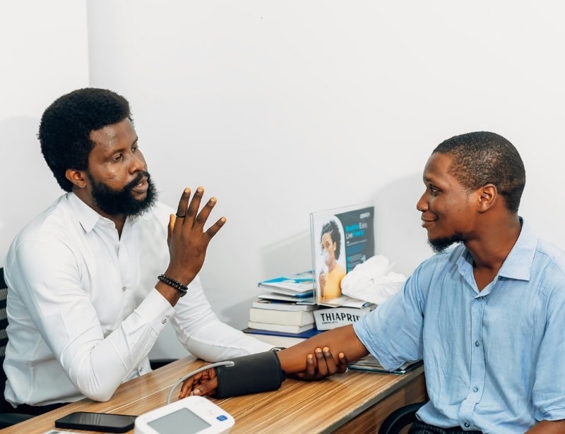 doctor taking blood pressure of man