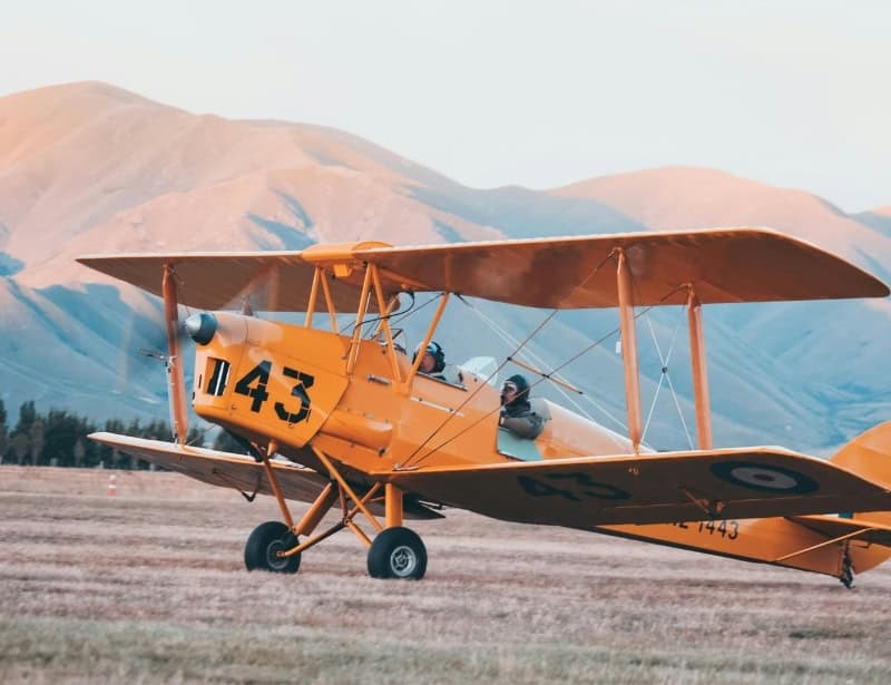modern yellow biplane taking off
