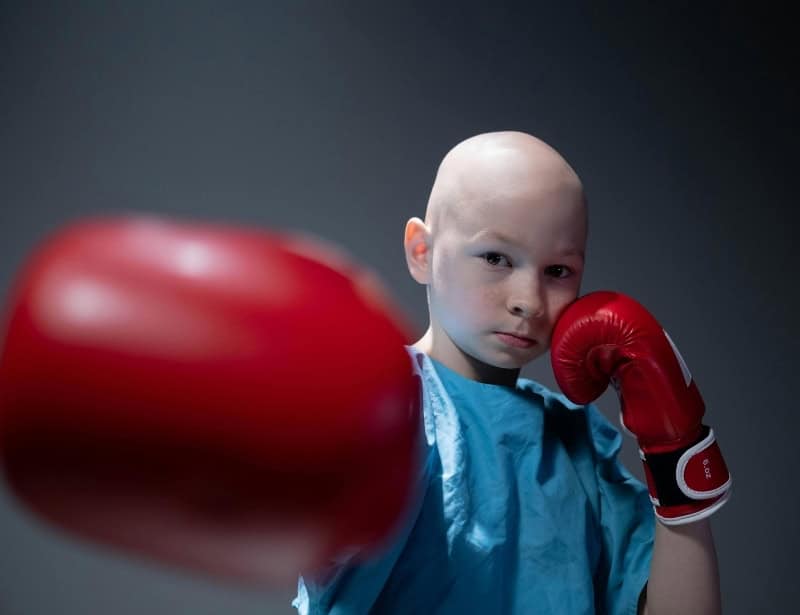 bald child posing punch with red gloves