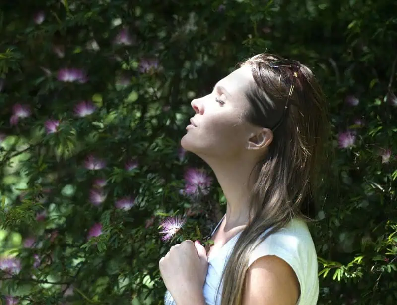 closed eyes woman breathing deeply in garden