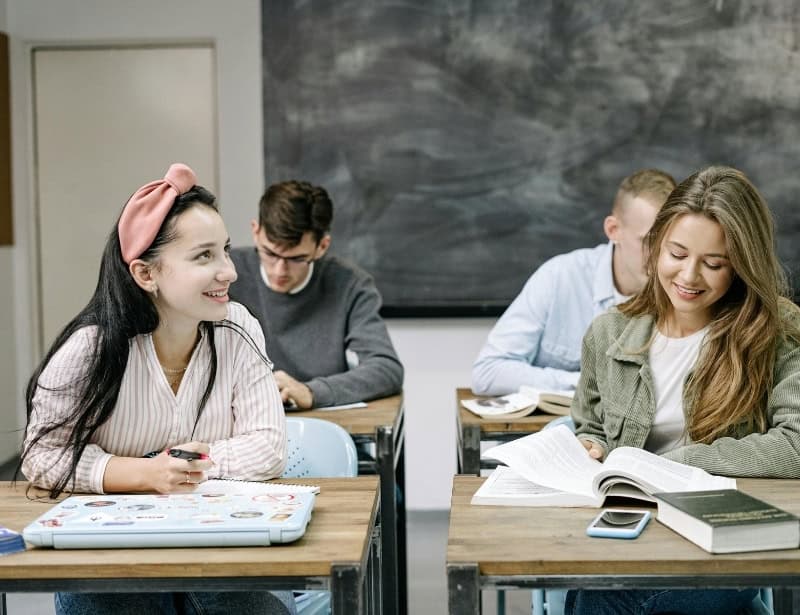 students on desks smiling and studying