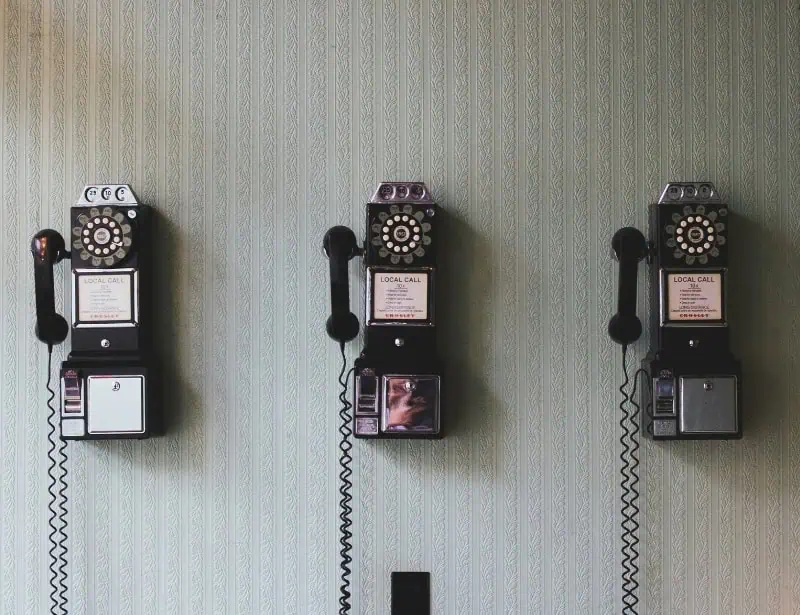three rotary dial telephones on wall