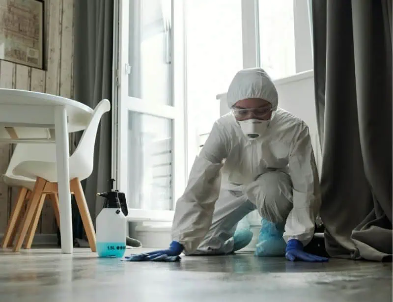 cleaner wearing white ppe on the floor cleaning