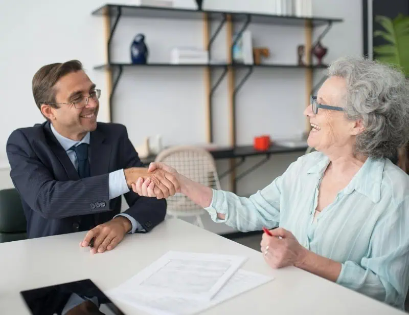 old lady shaking hands with advisor in suit