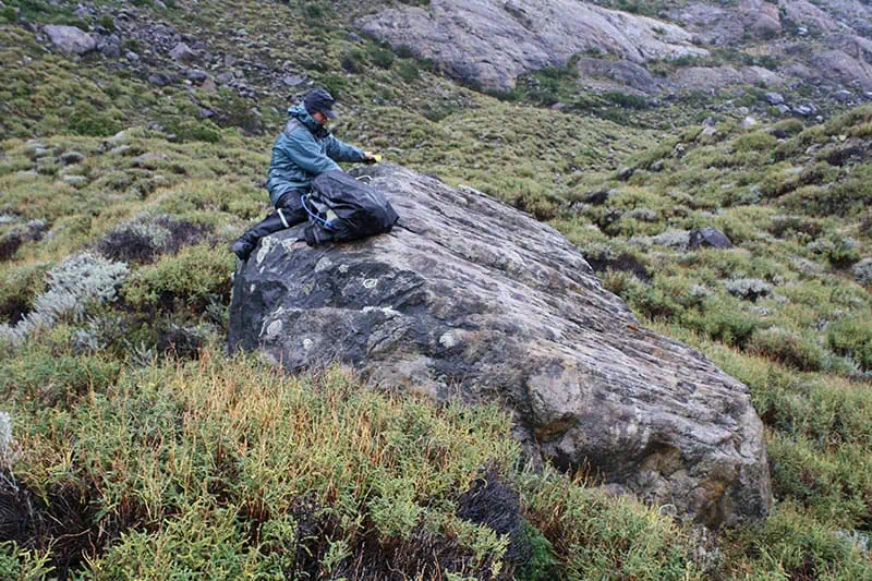 Mike Kaplan on a rock taking samples
