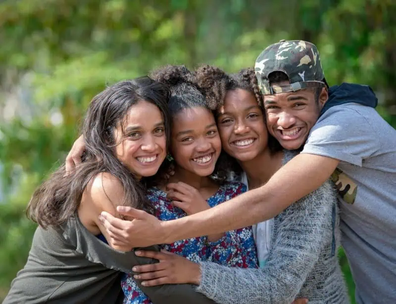 four-smiling-hugging-siblings