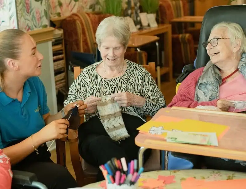 woman and two female elders knitting and smiling