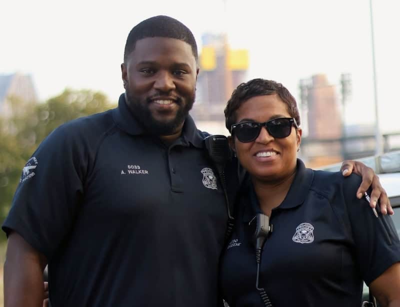 black police man side hugging black police woman