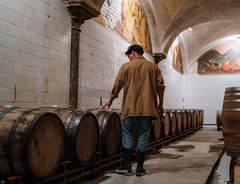 man walking to check barrels of rum