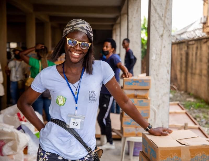 woman smiling holding food donation during non profit event