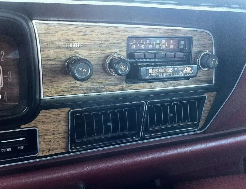closeup of eight track tape player in a vintage car with wood accents