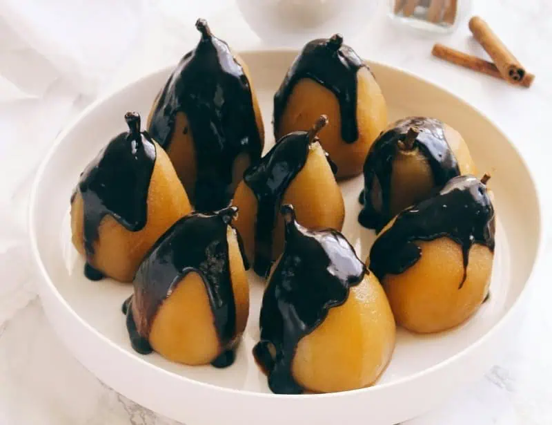 eight pears on white plate drizzled with chocolate sauce