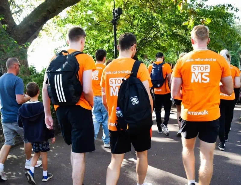 group of people wearing orange shirt walking to stop ms 