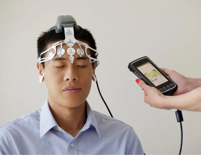 man wearing blue polo with portable eeg device