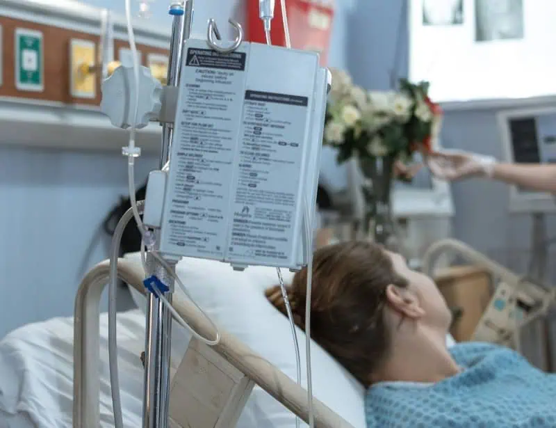 patient on hospital bed with focus on iv drip with warning list 