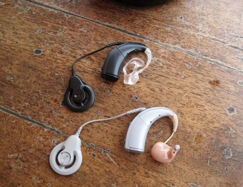 two black and white cochlear processor with electric acoustic stimulation on wooden table 