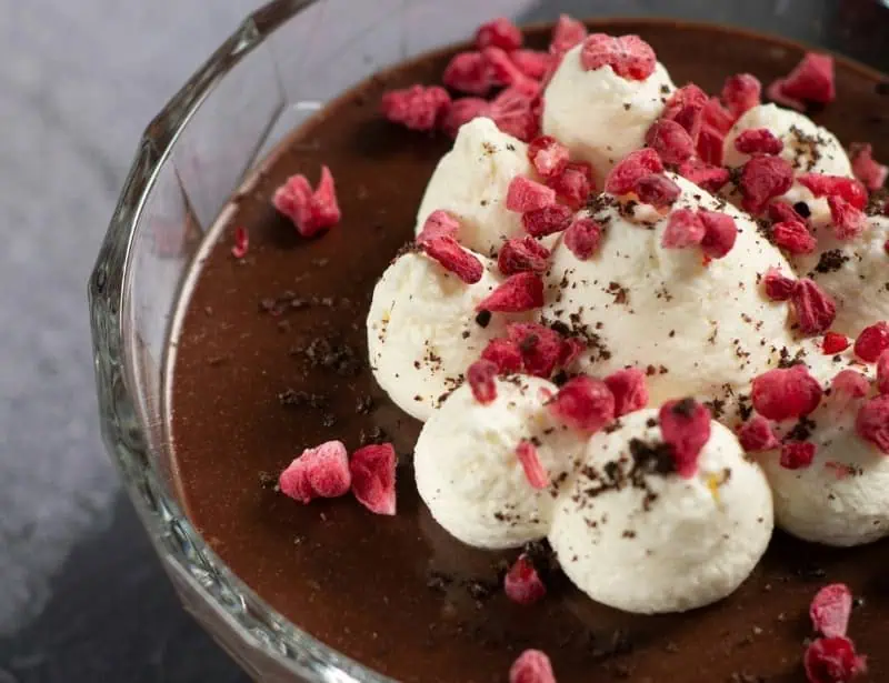 chocolate custard topped with cream and raspberry bits